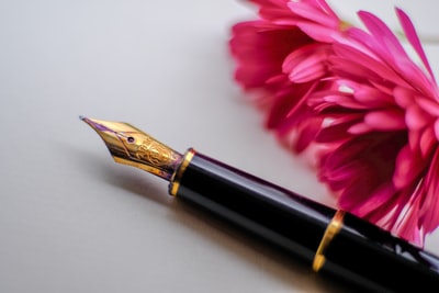 花旁的黑色和金色钢笔
